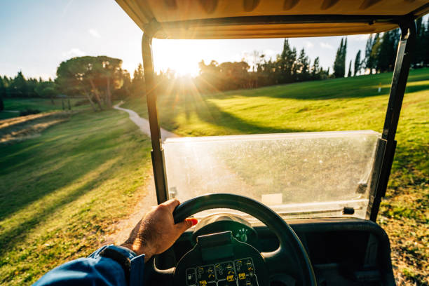 First-person view from inside a golf cart showing sun streaming over a traditional fold-down windshield — illustrating the UV exposure gap medical researchers have documented in vehicle interiors.